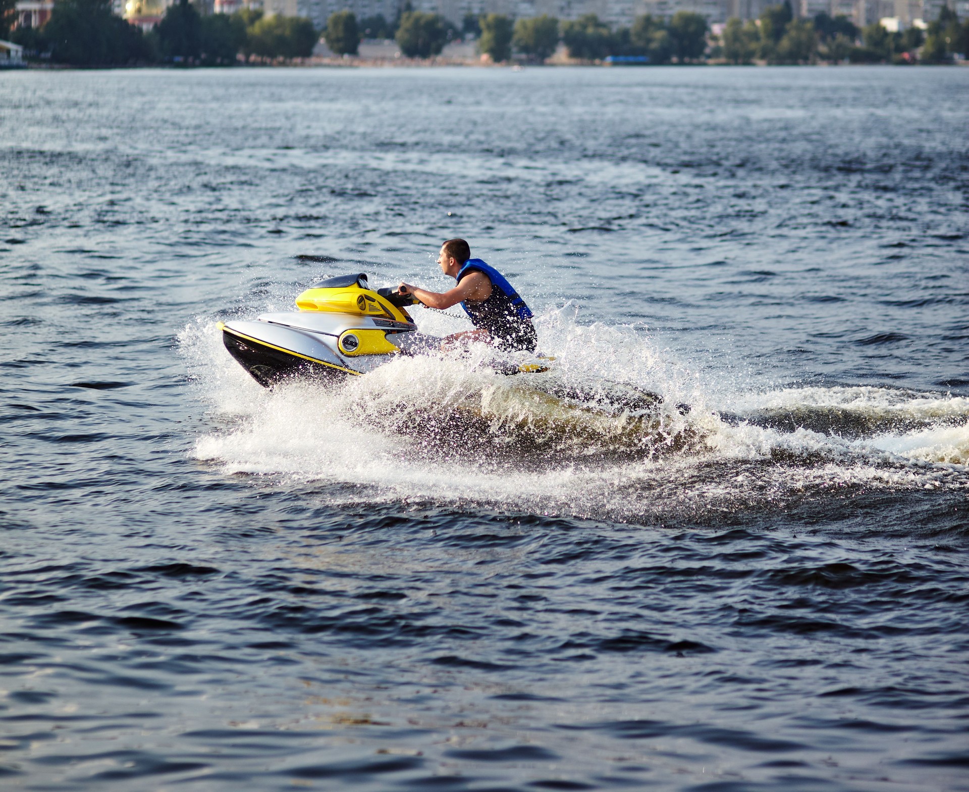 Man speeding on jet ski on lake during summer vacation