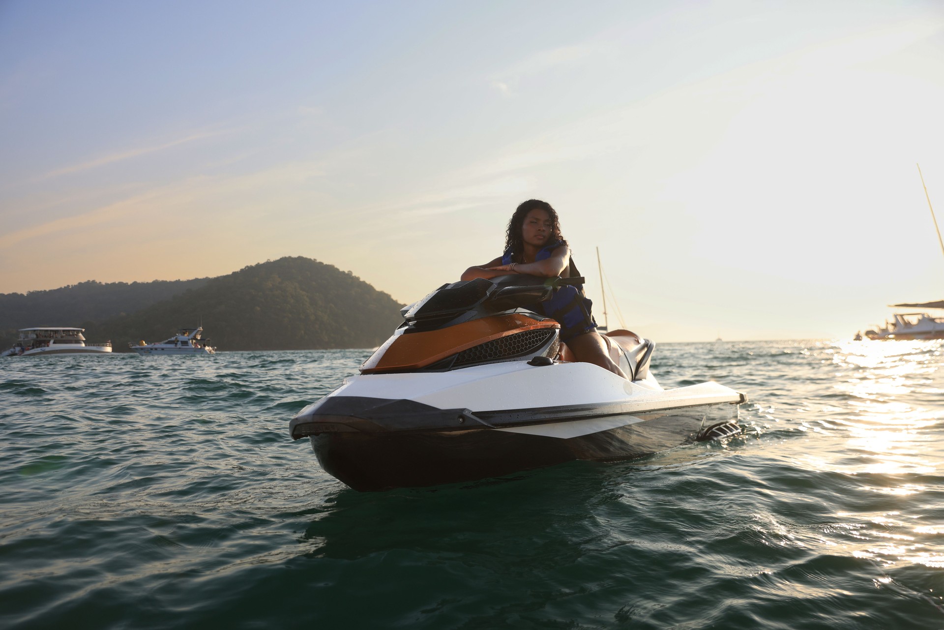 Black female having fun in summer, riding a jet ski. Summer vacation vibe, great time, blue sea and sky