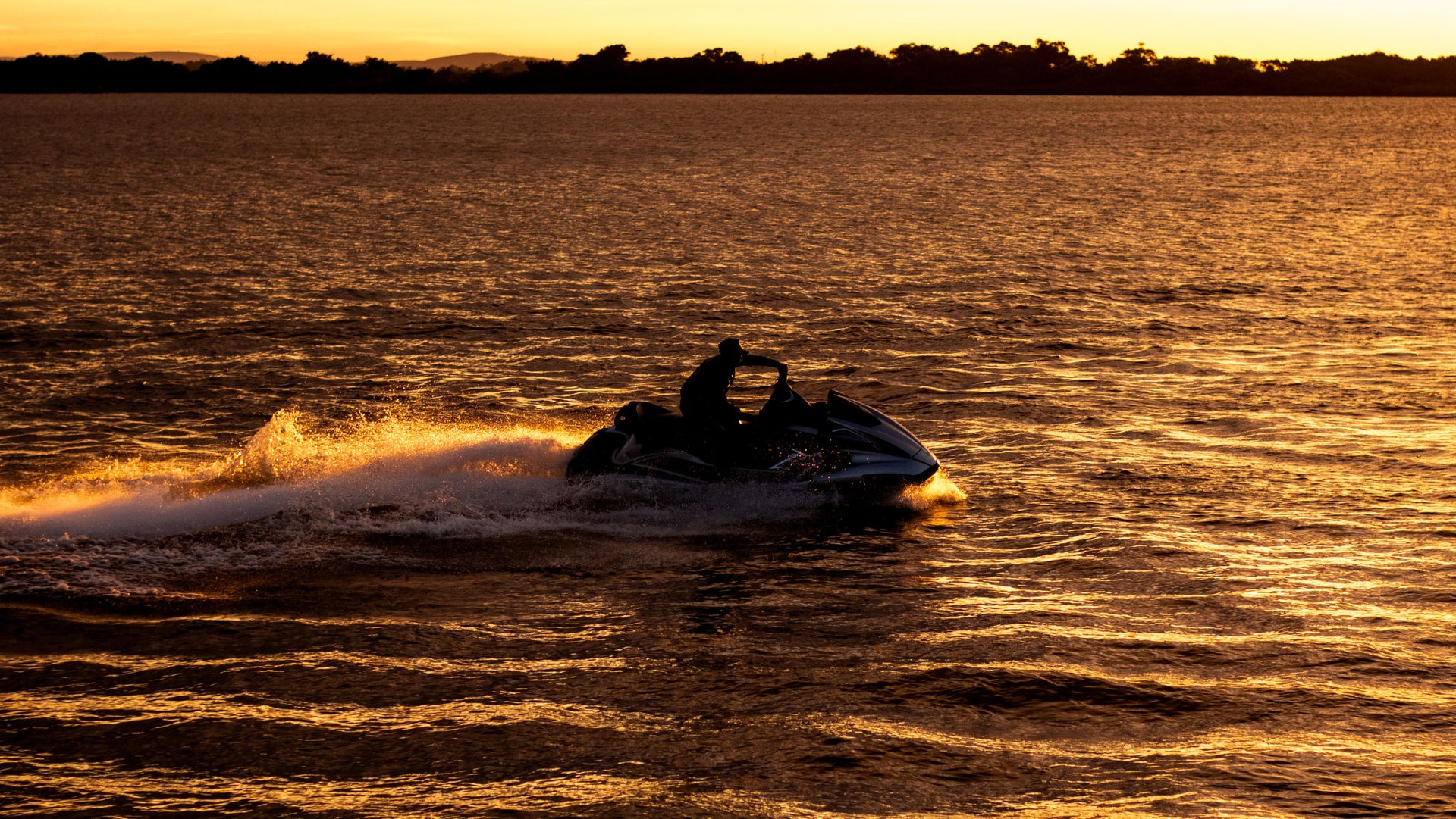 A man riding a jetski at sunset